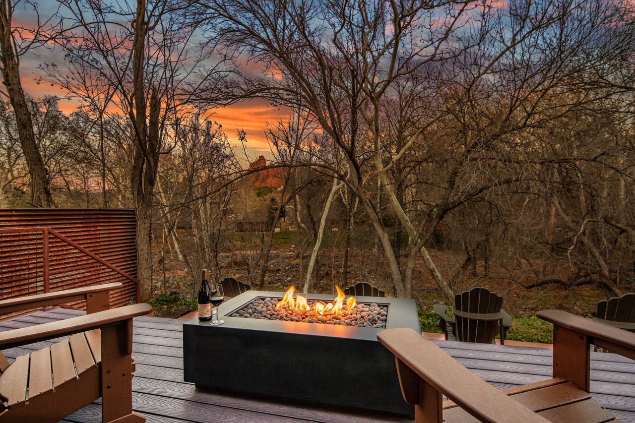 Fire feature deck with Adirondack chairs and red rocks at sunset