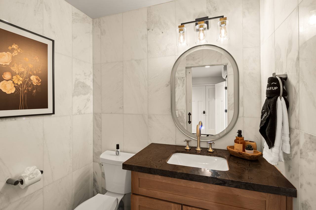 Bathroom with marble tile and brass fixtures
