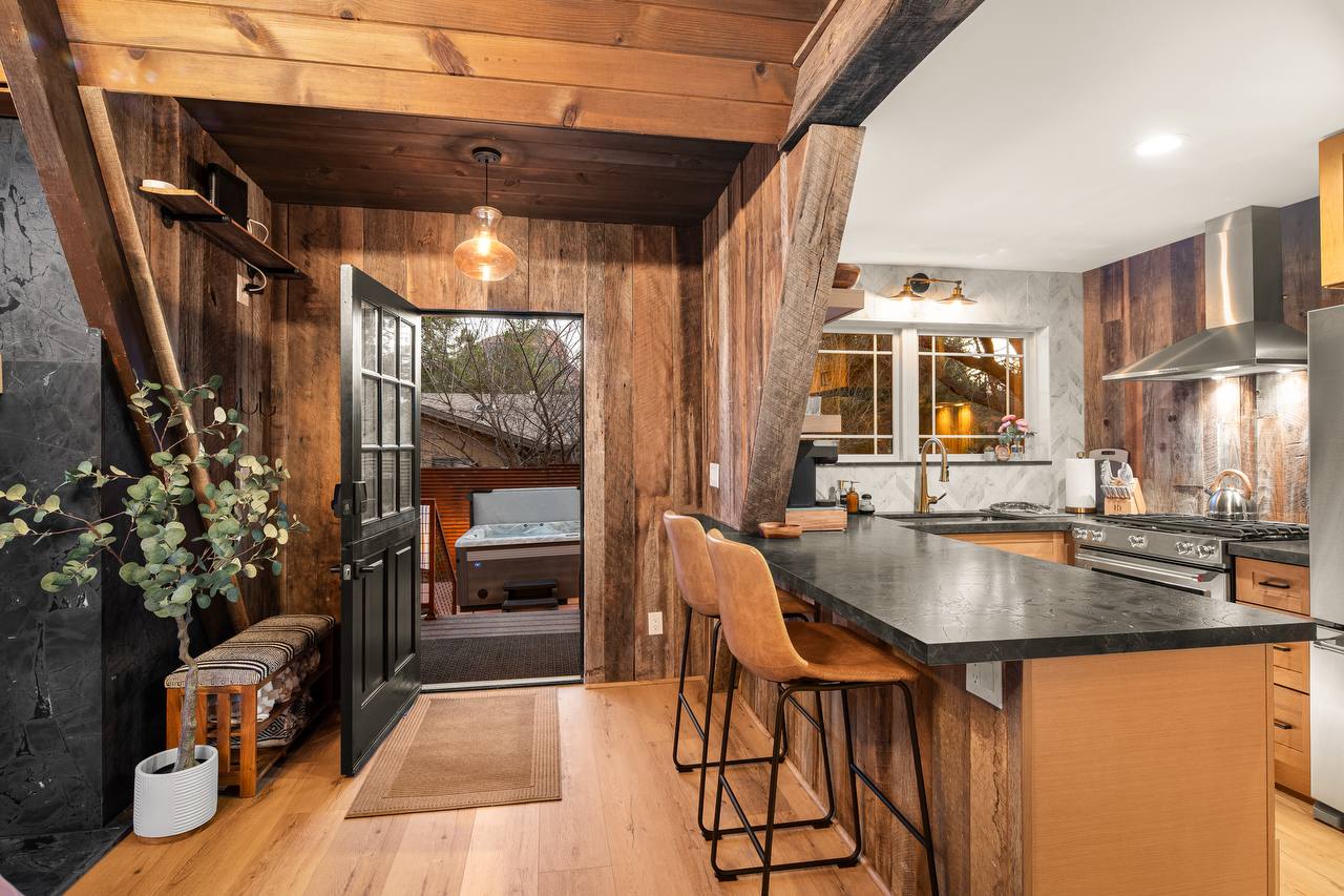 Kitchen and entry with obsidian countertops and hot tub through dutch door