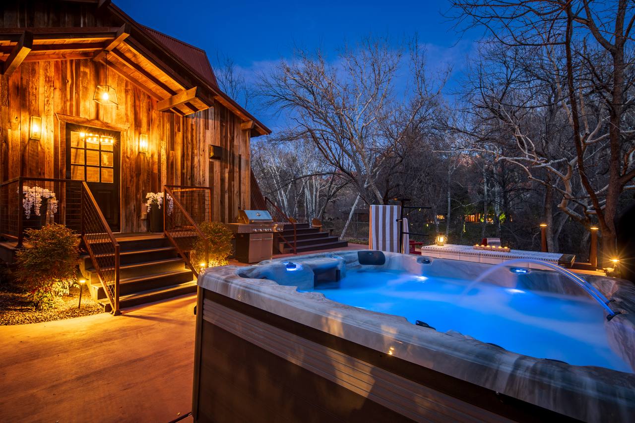 Hot tub glowing at blue hour with cabin