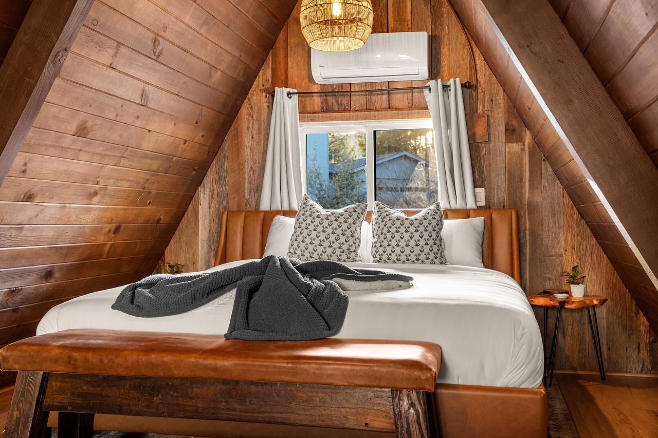 Loft bedroom with A-frame ceiling and leather headboard