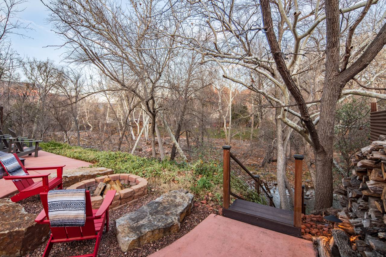 Backyard with fire pit, creek stairs, and red rock views